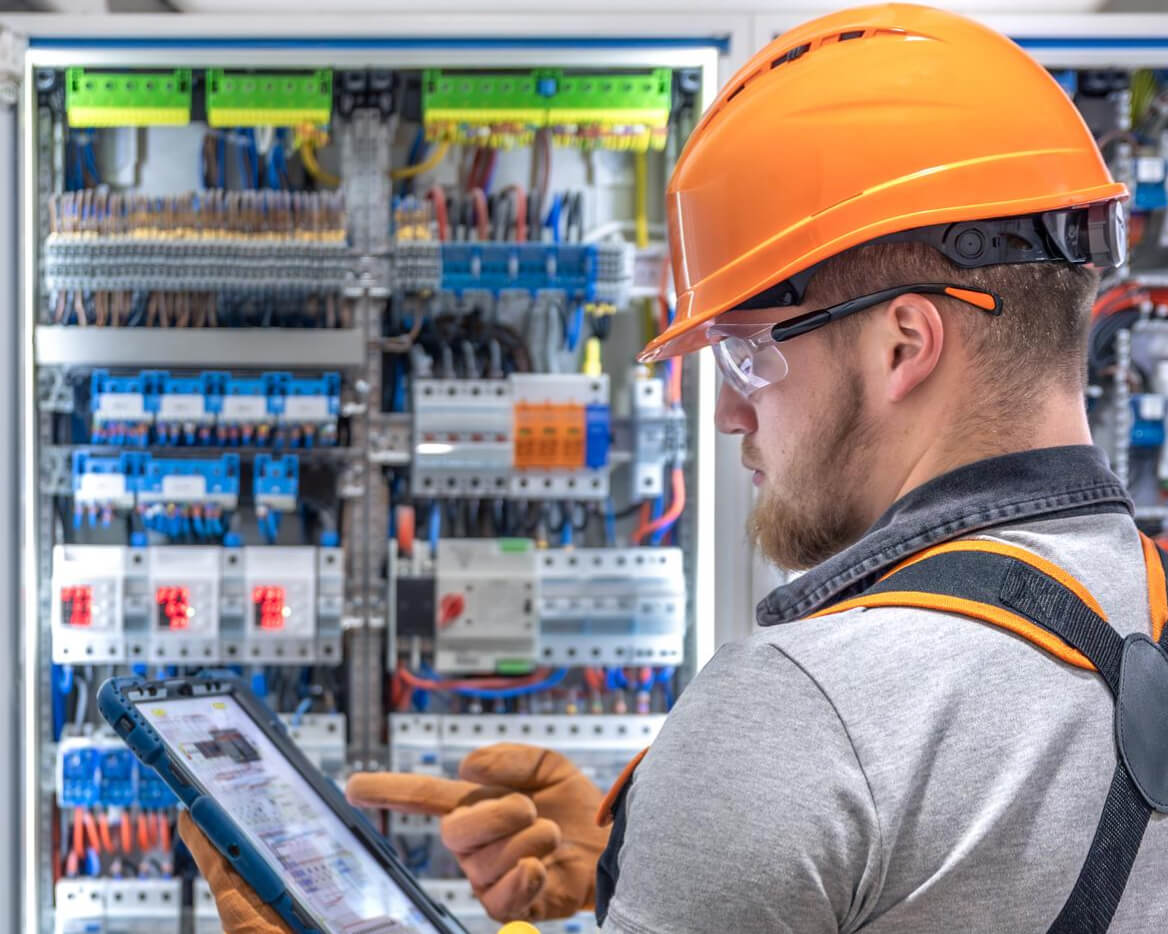 Elektriker prüft Schaltanlage als Unterscheidungsmerkmal von Elektro Schweiss