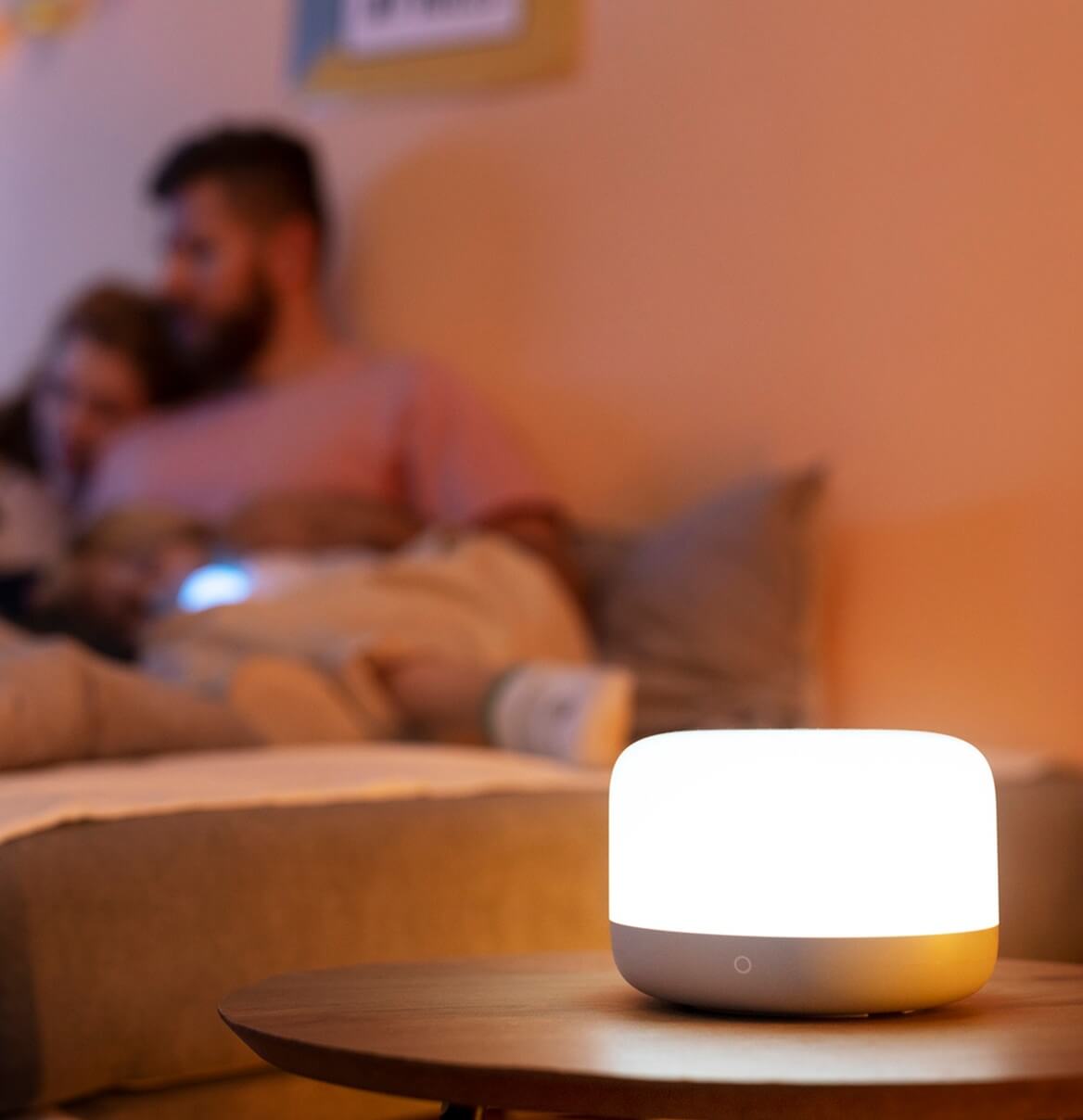 Frau sitzt entspannt auf Sofa unter Stehlampe mit warmem LED-Licht