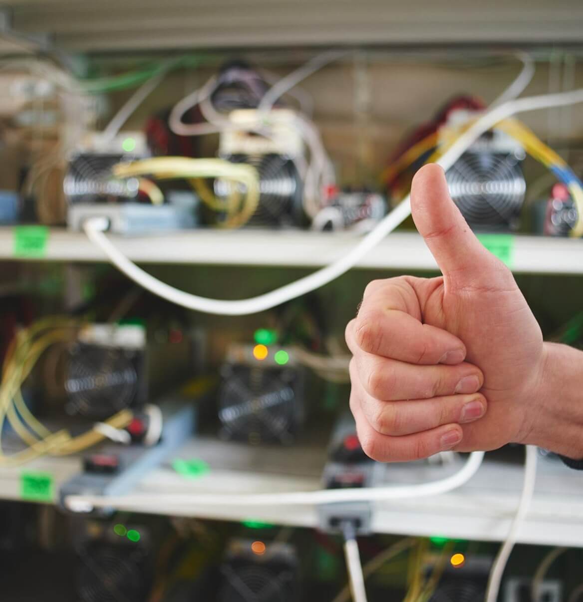Daumen hoch vor Netzwerktechnik und Serverrack im Rechenzentrum