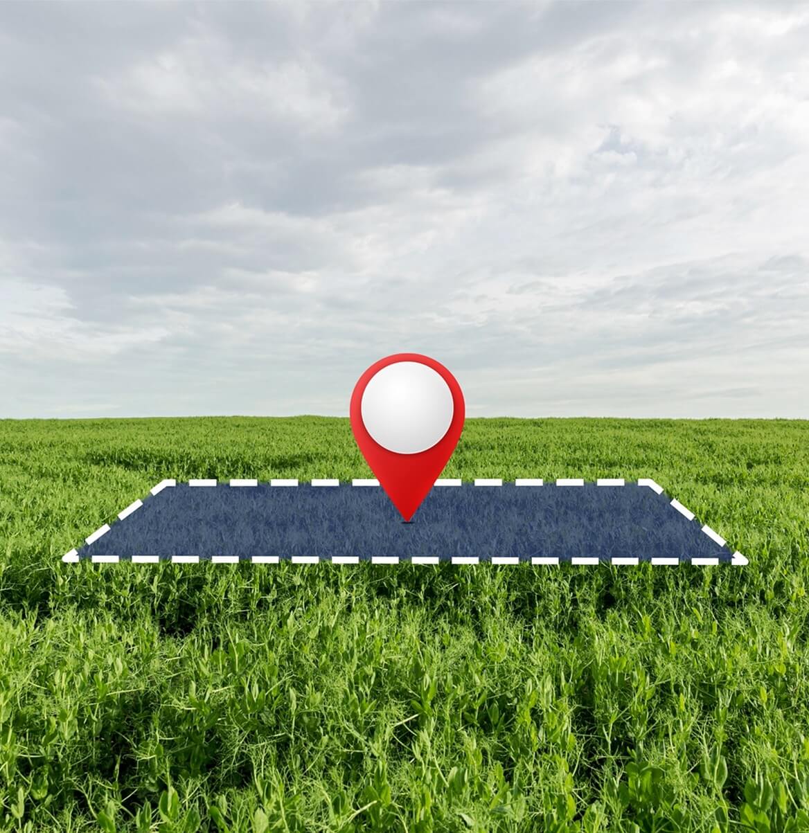 Solarmodul auf grüner Wiese mit rotem Standort-Pin als PV-Freiflächenstandort