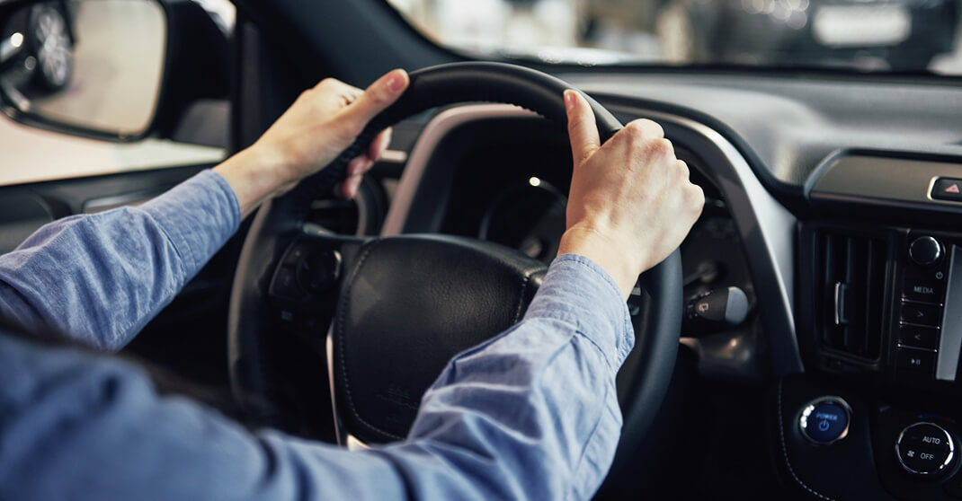 Fahrer hält Lenkrad von innen beim Fahren mit Elektrofahrzeug