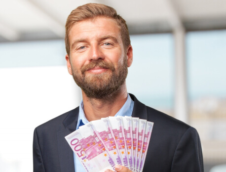 Geschäftsmann in Anzug hält Euro-Scheine als Symbol für Einsparungen durch Solarstrom